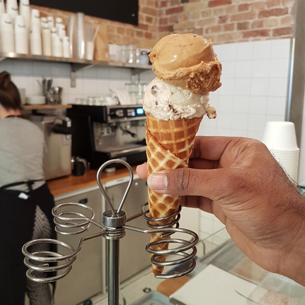 Scoop of fudge-chocolate-peanut and banana-chocolate-marshmallow ice cream in a handmade waffle cone
